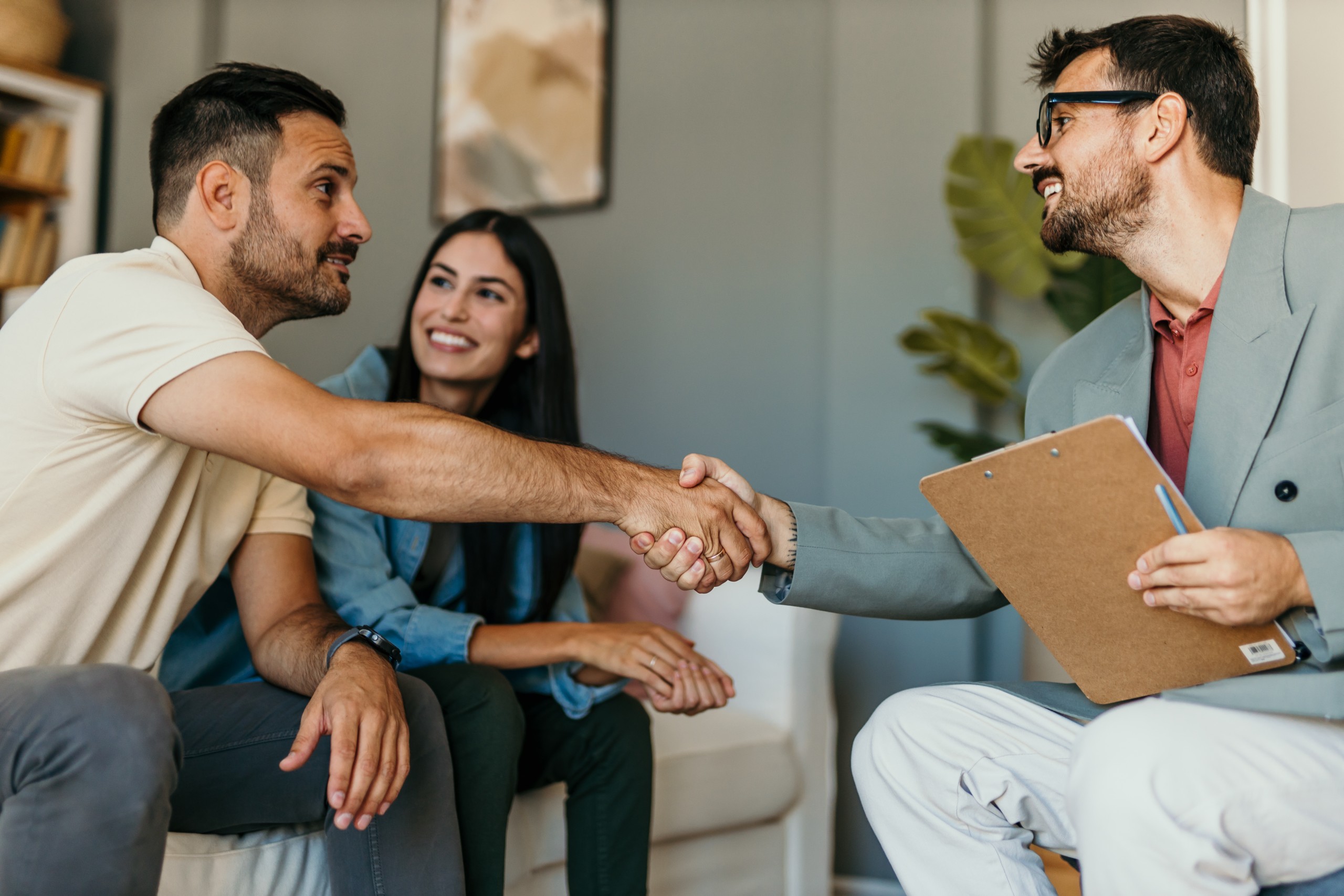 Young couple shaking hands deal contract real estate investment business agreement agent handshake signing Remax Billboard